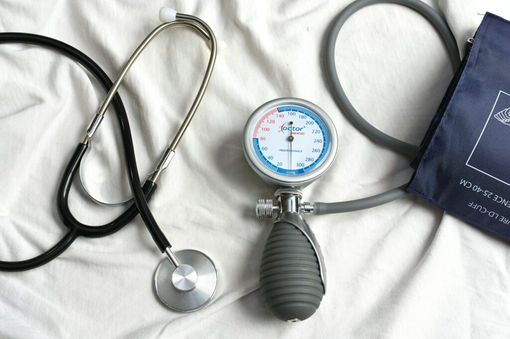 un stéthoscope posé sur un lit à côté d’une trousse médicale