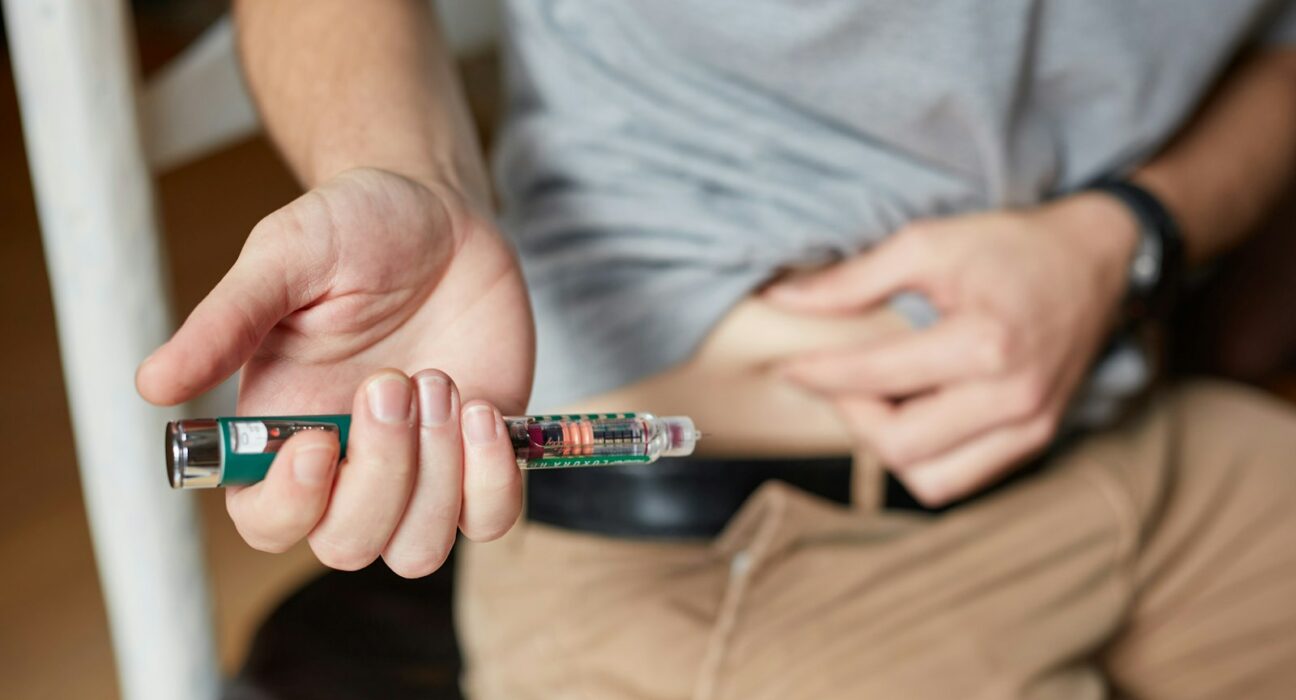 une personne qui tient une injection d’insuline ;
