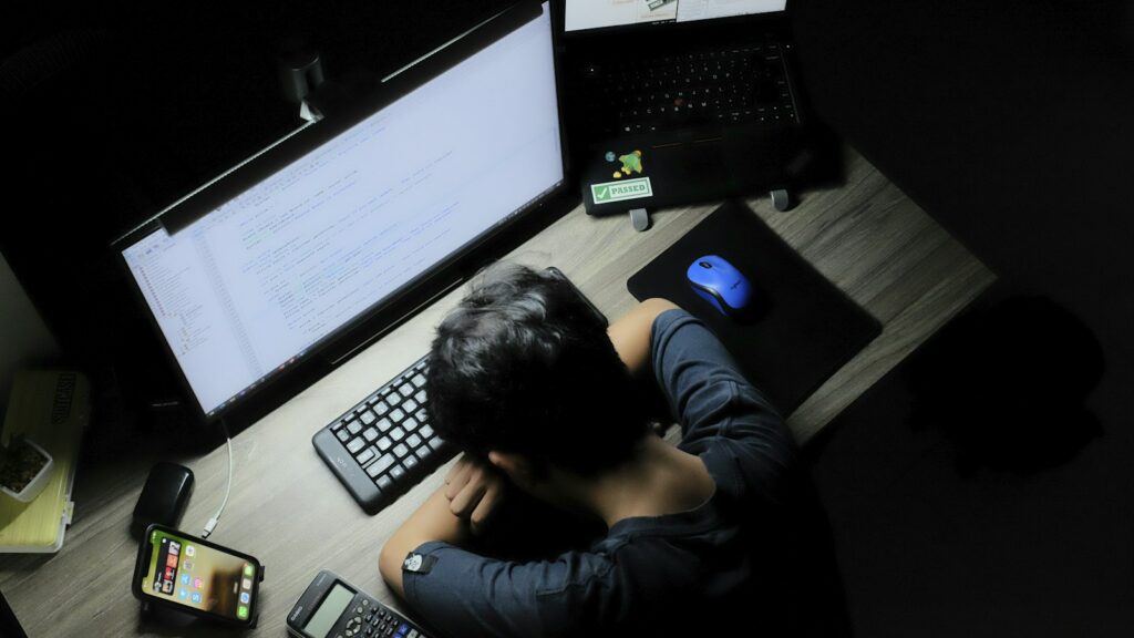 Un homme assis devant un écran d’ordinateur