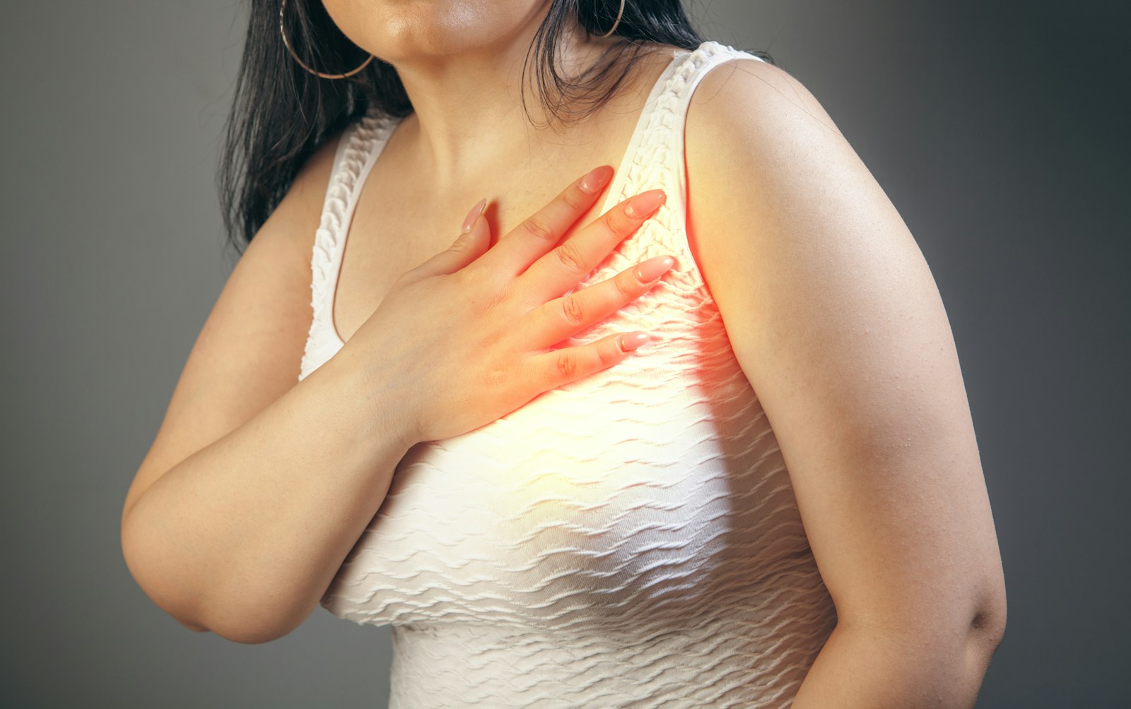 Femme tenant sa poitrine d’une main