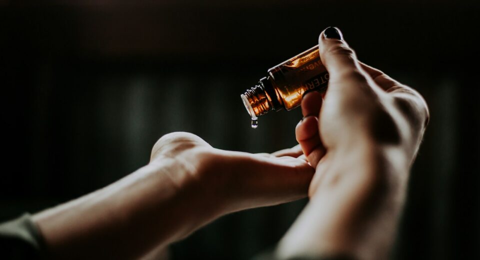 personne tenant une bouteille en verre ambré