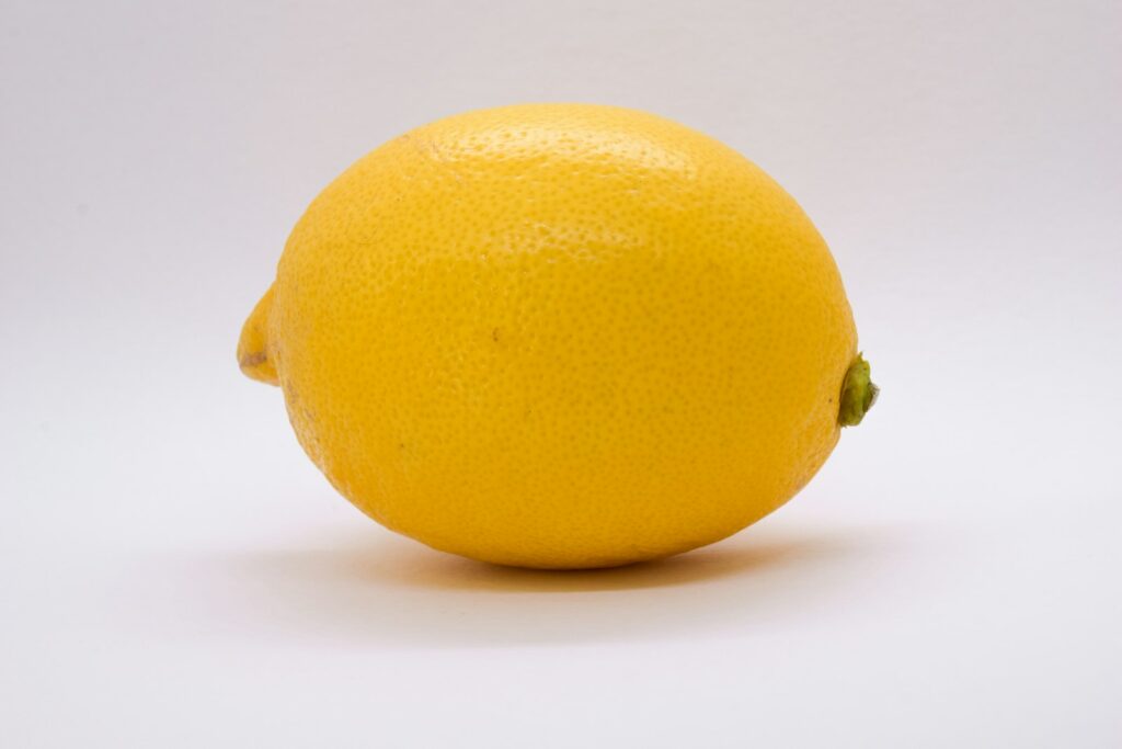un seul citron posé sur une table blanche