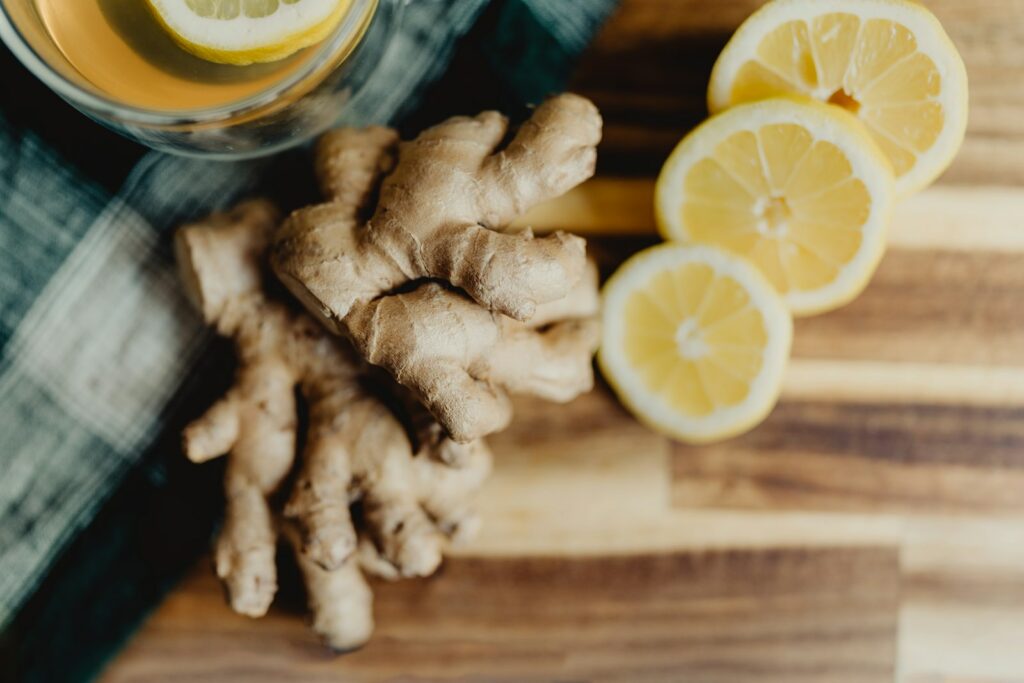 un verre de jus d’orange à côté de citrons tranchés et de gingembre